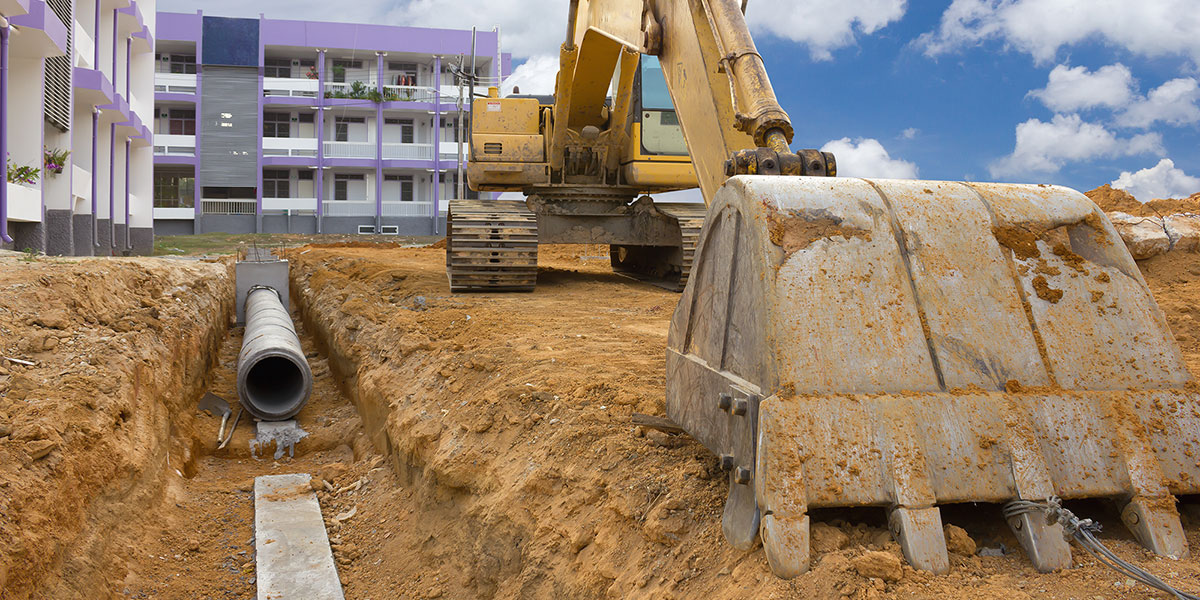 Backhoe preparing to bury an underground water main